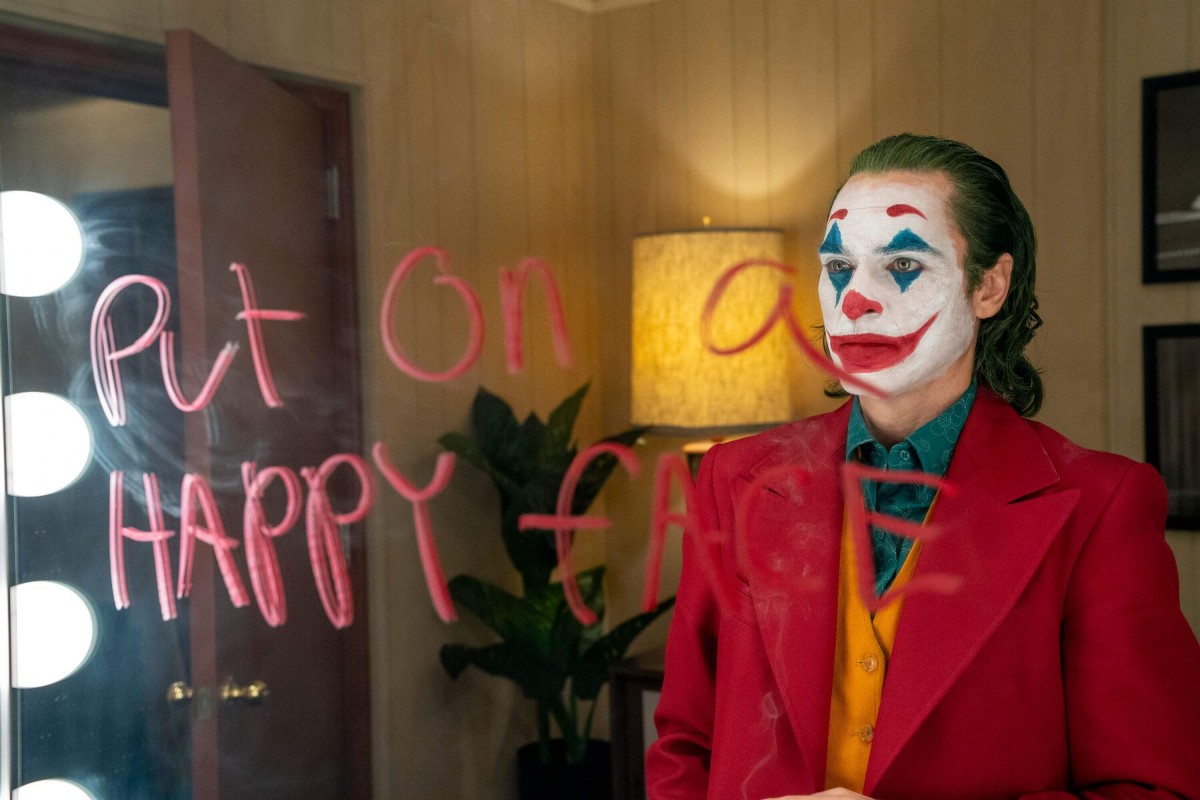 Joker menulis “put on a happy face di cermin”